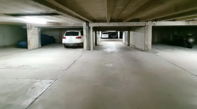 Tiefgarage mit Stellplätzen, im Hintergrund parkende Autos
